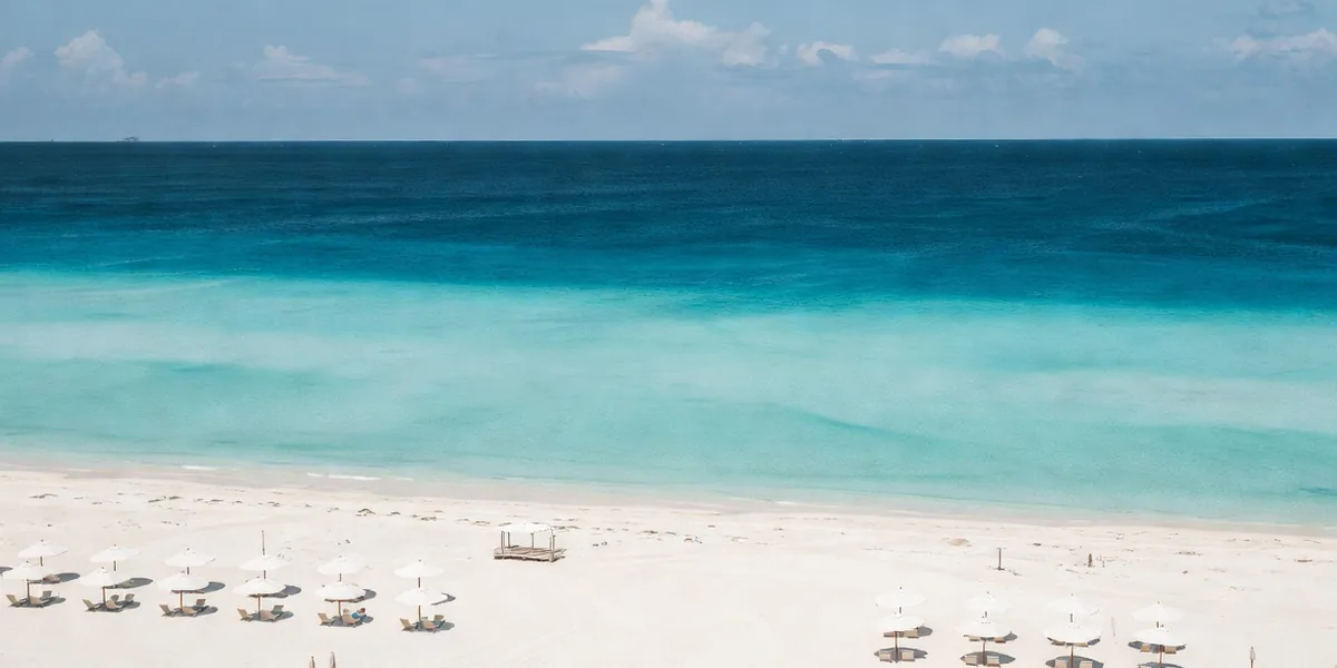 White sand and layered blue water of the Caribbean at Playa Delfines in Cancún's Hotel Zone