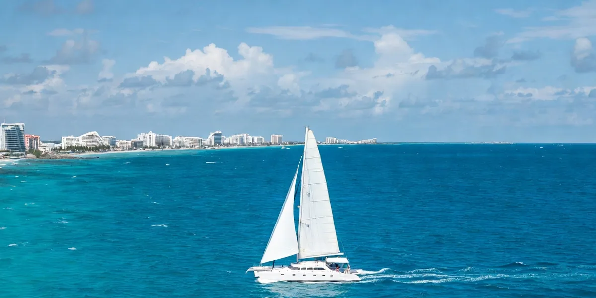 Catamaran sailing from Cancún's Hotel Zone toward Isla Mujeres over turquoise Caribbean water