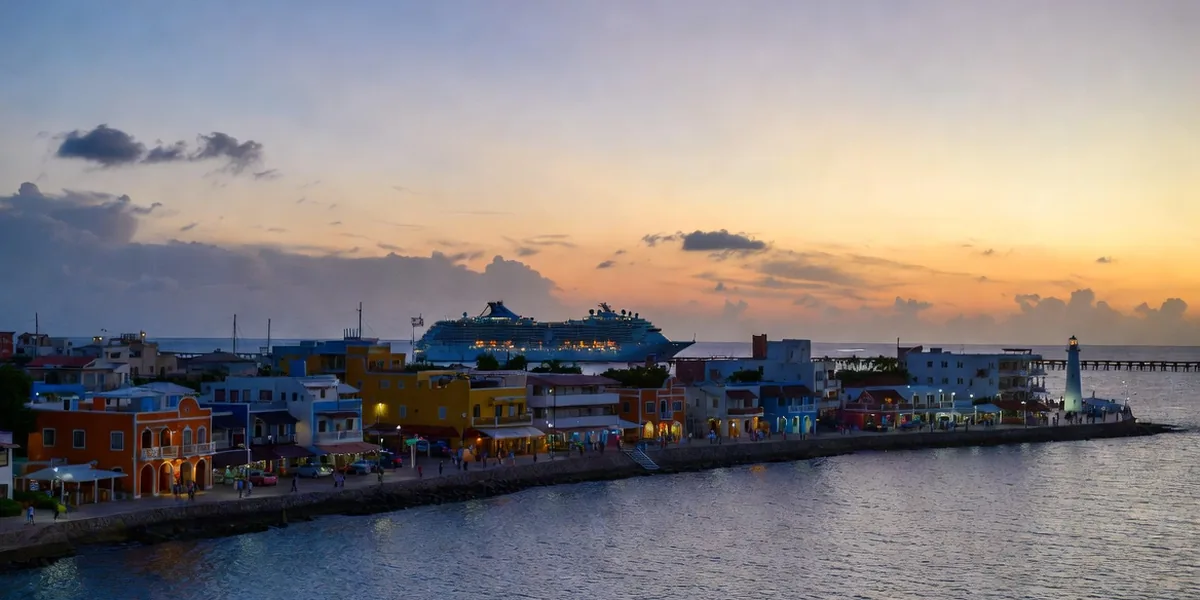 San Miguel waterfront in Cozumel at dusk with a cruise ship docked offshore