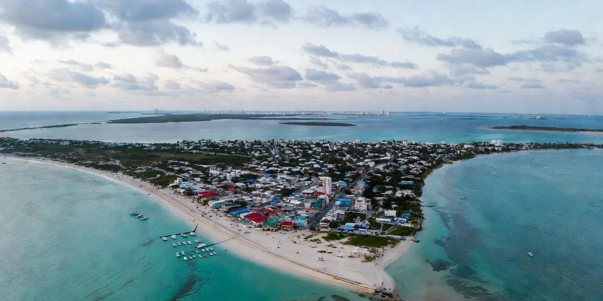Aerial view of the north tip of Isla Mujeres with Playa Norte, town rooftops and reef-band water