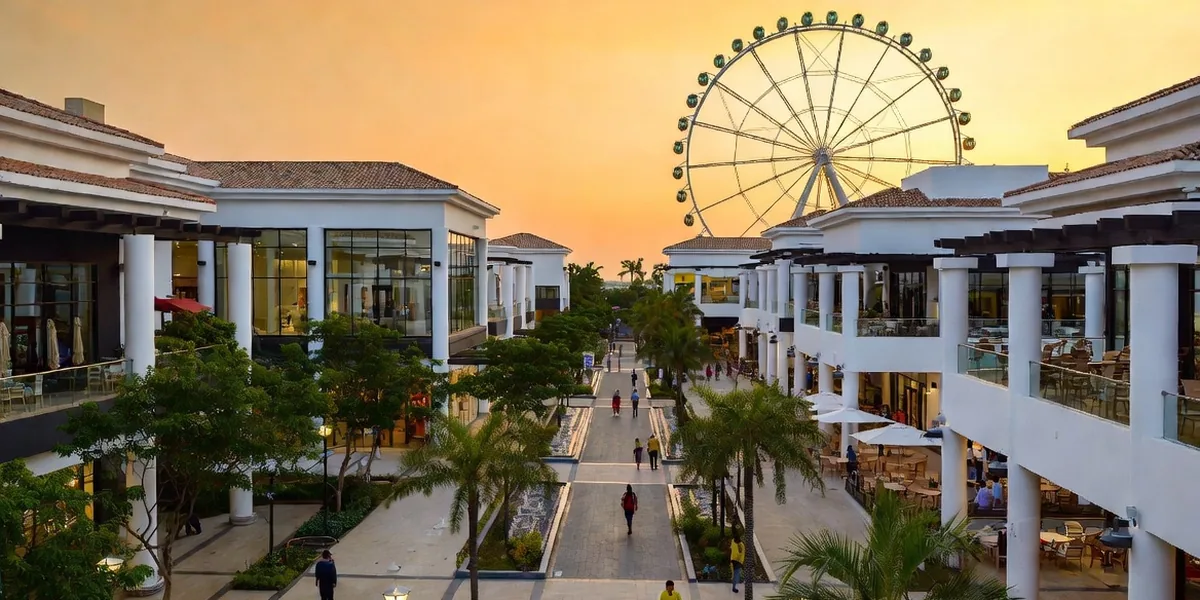 Open-air shopping plaza with fountains, palms and a big ferris wheel in Puerto Vallarta
