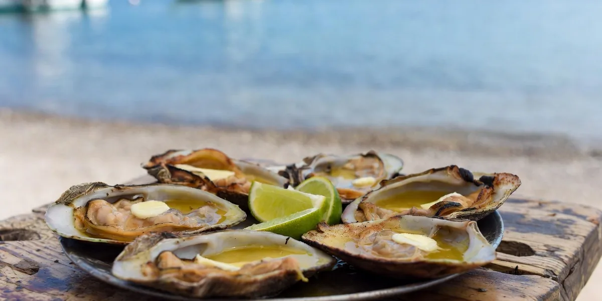 Grilled chocolate clams with lime at a beachside table near the La Paz malecón
