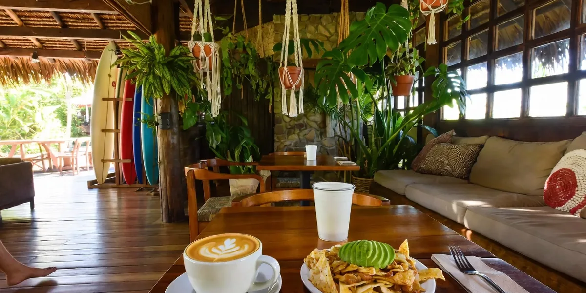 Latte art and chilaquiles on a jungle-boho café table in Sayulita